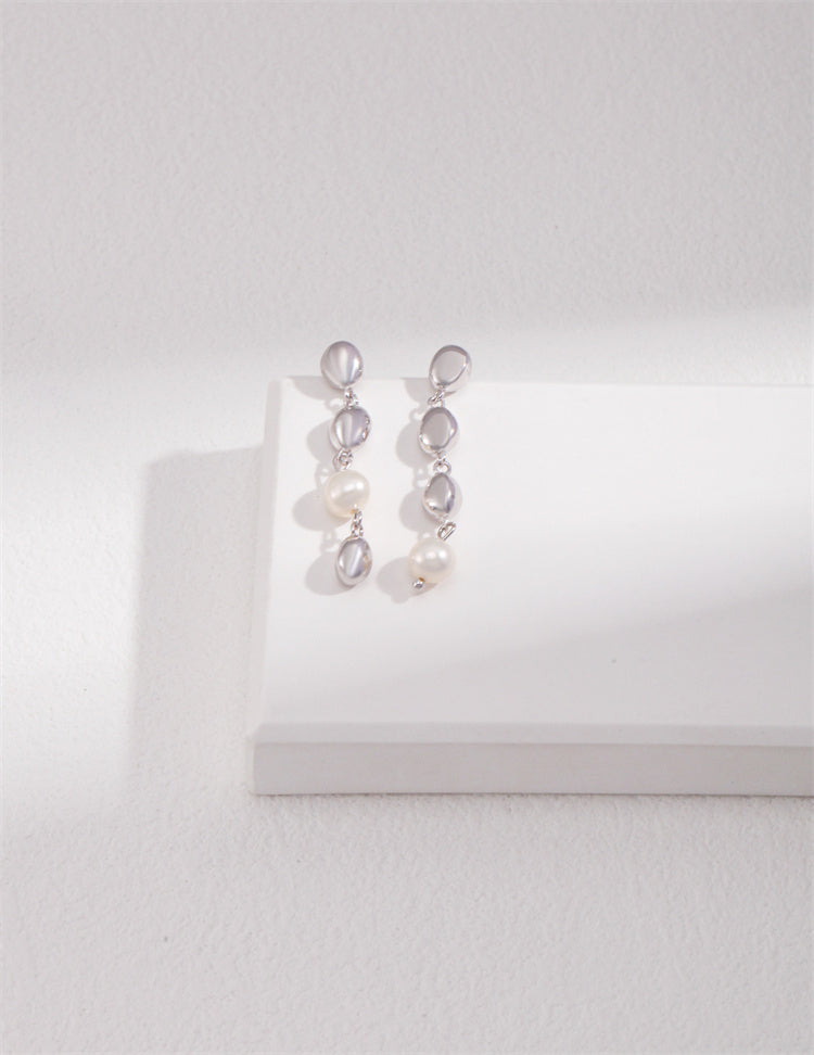 A set of S925 silver pearl drop earrings displayed on a white platform, with one earring in a platinum finish and the other in a vintage gold finish, showcasing the natural pearl and the elegant design.