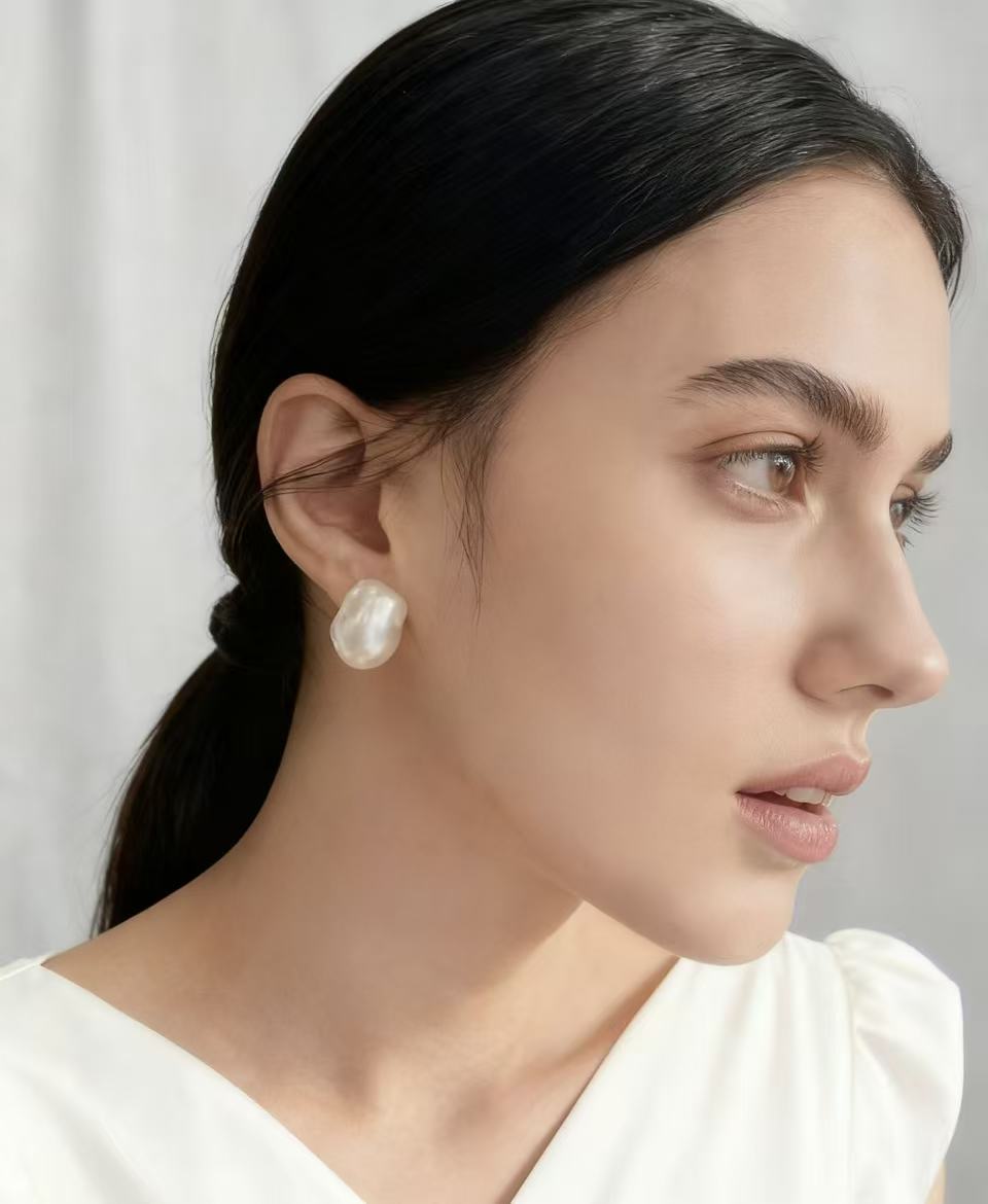Woman with big baroque pearl stud earrings